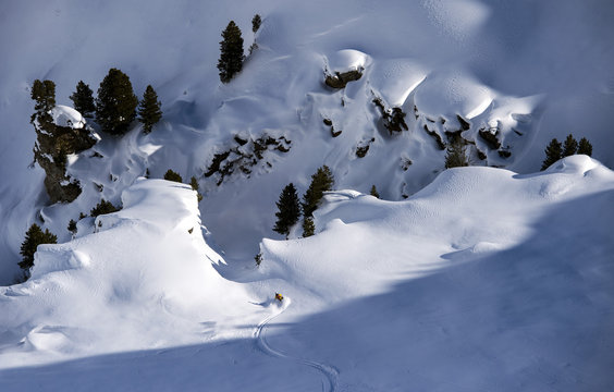 Skier skiing down into a gorge full of snow, Hochfuegen, Zillertal, Austria