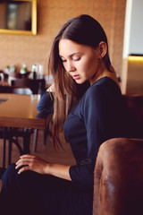 Young brunette sitting in a restaurant