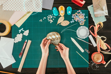 cropped image of designer making scrapbooking decoration for postcard in shape of balloon