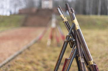 the old rifles are stacked with a hut