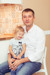 Handsome young father with his cute little girl at home