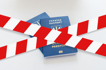 White and red warning tape over the two Ukraine passports.