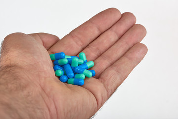Fototapeta na wymiar The hand of a man with different types of medication, Medicine pills or capsules in hand, palm. Colorful pills and medicines in the hand