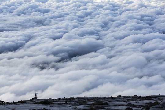 Person on cloud covered top of Mount Kinabalu, Malaysia