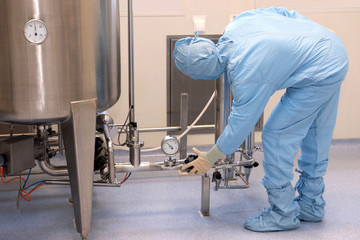 Repair and adjustment of medical equipment. Validation of the machine for the production of pharmaceutics. Man repairing a machine for the production of medicines. Repairs to the machine hands of men.