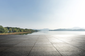 empty marble floor with beautiful lake in blue sky