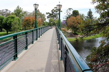 Crossing a bridge leading into a park with exotic flowers