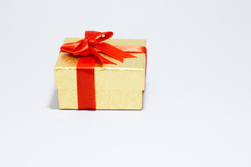Gloden gift box with red bow on white background