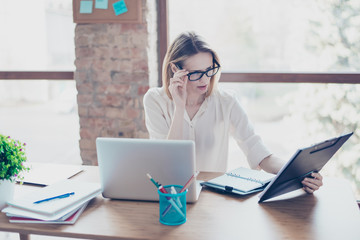 Qualified clever intelligent female boss is carefully analyzing the contract in her hand, she is...