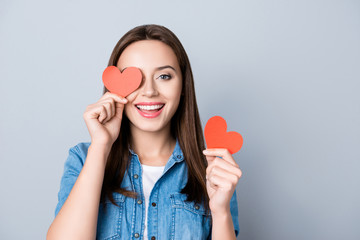 Close up portrait of brunette, charming, pretty girl, having two small red hearts in  hands,...