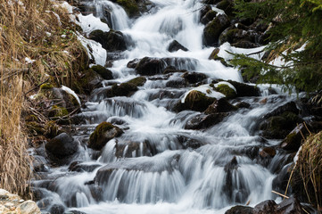 Fototapeta na wymiar Majestic small stream cascading down a mountain slope in the Austrian Alps (long exposure)