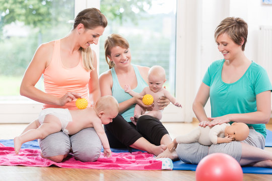 Young Women Practicing Massage For Their Babies In Mother-child Class