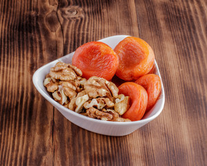 Mix of dried fruits and nuts on a dark wood background