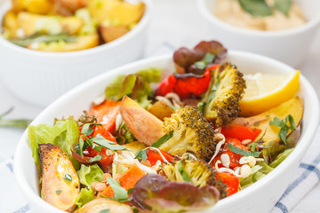 Salad with baked vegetables: potatoes, carrots, peppers and broccoli.