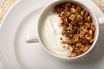 Healthy breakfast: Greek yogurt with homemade granola in a white bowl