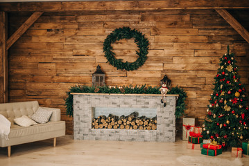 Wooden walls, fireplace, sofa and Christmas tree