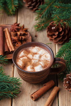 Cozy winter still life. Cup of hot cocoa with marshmallows and cinnamon on rustic wooden table.