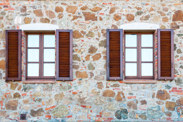 Fototapeta na wymiar Old wooden windows frame on stone wall in Italy.