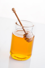 jar of honey with honeycomb on white