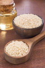 Seeds and sesame oil on the wooden table - Sesamum indicum