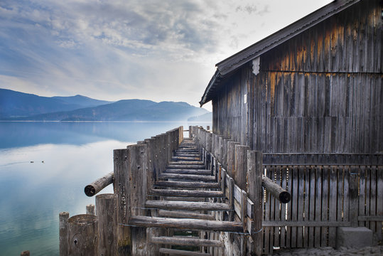Wooden boathouse on Lake Walchen on misty morning, Bavaria, Germany