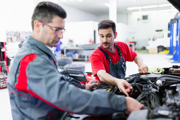 Car mechanics working at automotive service center