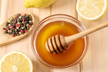 Honey with lemon and spice on a wooden background.