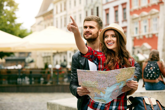 Couple Of Travelers Using Map For Sightseeing In Town.