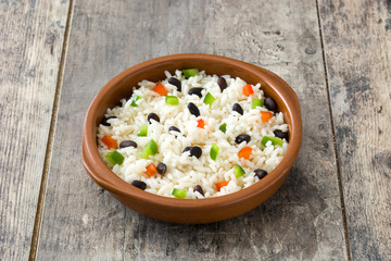 Traditional cuban rice, black beans and pepper on wooden table background. Moros y cristianos.

