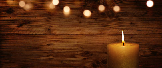 Fototapeta na wymiar Candle with wooden wall and bokeh