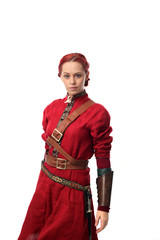portrait of red haired girl wearing red medieval out fit, studio background.