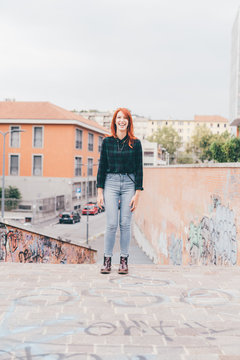 young woman redhead outdoors looking camera smiling - happiness, crefree, customer concept