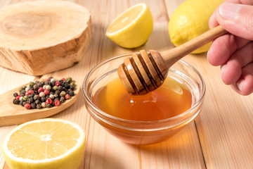 Honey with lemon and spice on a wooden background.