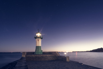 Leuchtturm auf einer Kaimauer am Abend im Winter