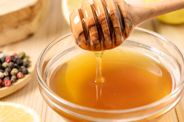 Honey with lemon and spice on a wooden background.