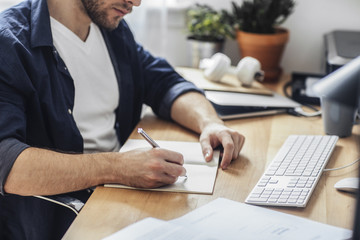 Man Writing in Notebook