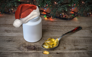 Fish oil omega 3 capsules in container on wooden background with Christmas tree. Nutritional supplement gift from Santa Claus