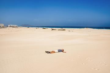 Fototapeta na wymiar young man in the dunes in Fuerteventura, Spain