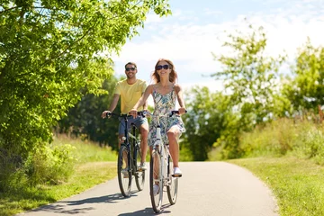 Vitrage gordijnen happy young couple riding bicycles in summer © Syda Productions
