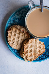Grilled cheese sandwich with tomato and cup of coffee with milk on light table background. Morninig concept