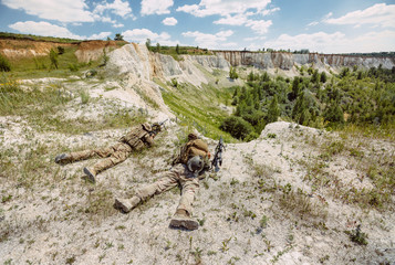 Army sniper during the military operation in the mountain. war, army, technology and people concept.