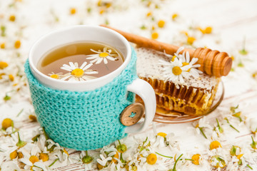 Honeycomb and chamomile tea on white
