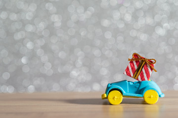 Toy Car with Christmas tree and gift box. Christmas landscape with gifts and snow. Merry christmas and happy new year greeting card with copy-space. Christmas celebration holiday background.