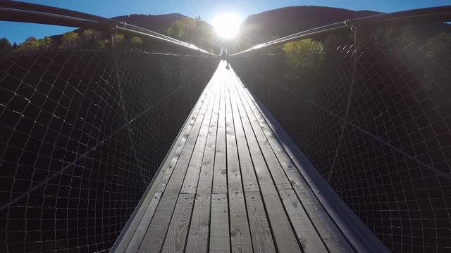 Walking on suspended wooden bridge. Tibetan bridge built in Switzerland