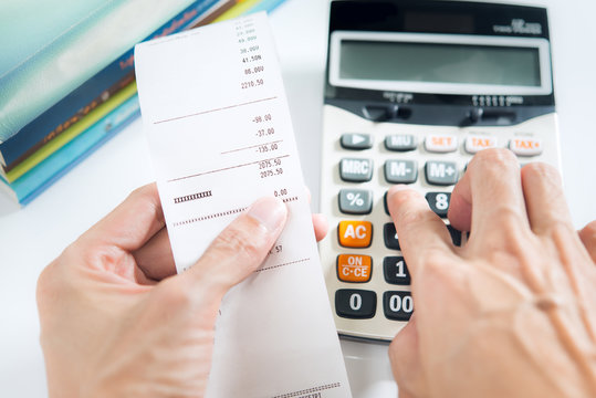 Grocery shopping list in hand with calculator - money account ma