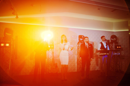 Musicial music live band performing on a stage with different lights.