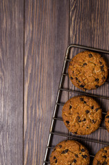 Homemade oatmeal cookies on cooling rack. Wooden background. Flat top view. Vertical photo