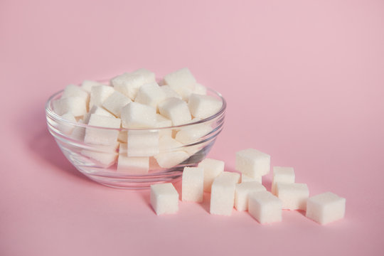 White Sugar Cubes In Glass Bowl On Pink Background