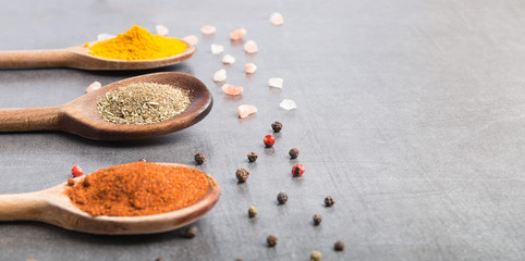 various spices in wooden spoons