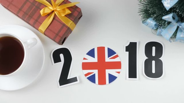 Illustration, new year, male hand put on the table an Great Britain flag, cauntry ball, 2018